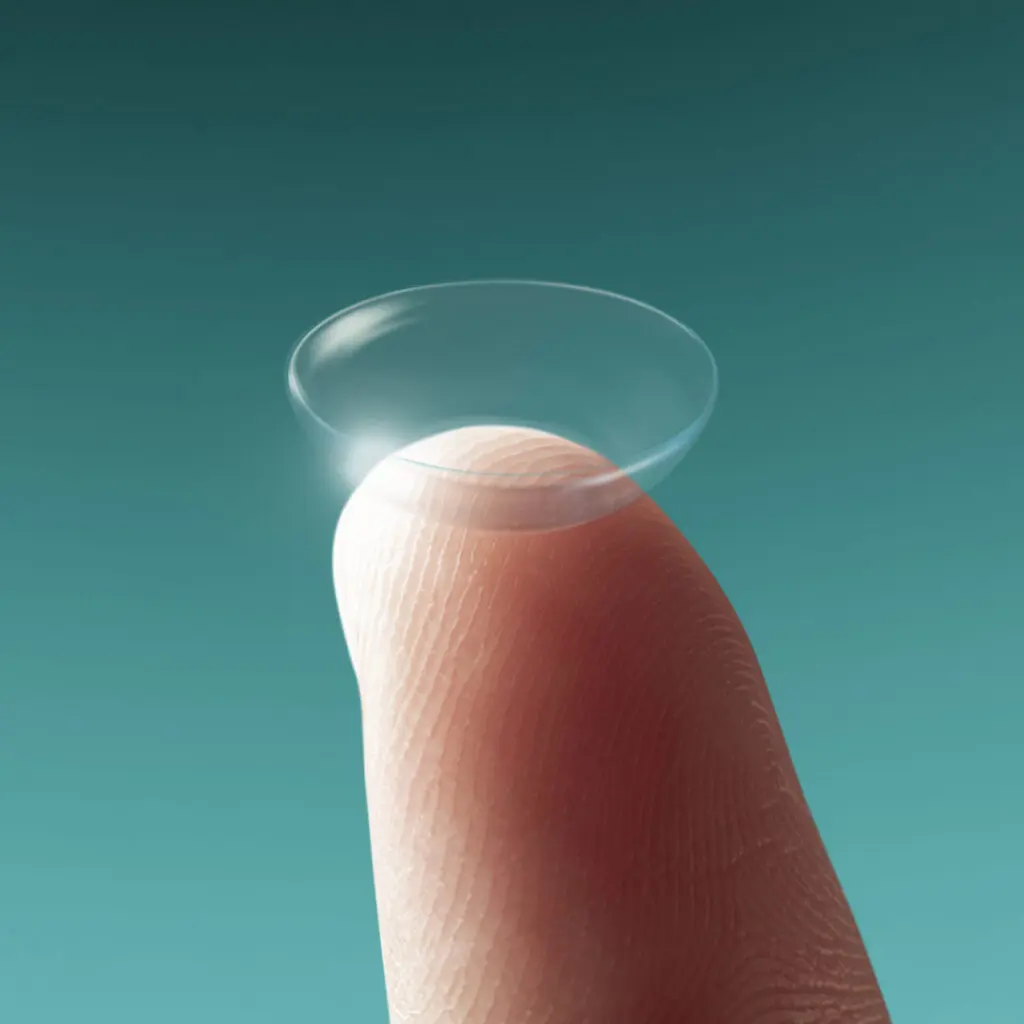 Close-up van een contactlens op de top van een vinger tegen een turquoise achtergrond